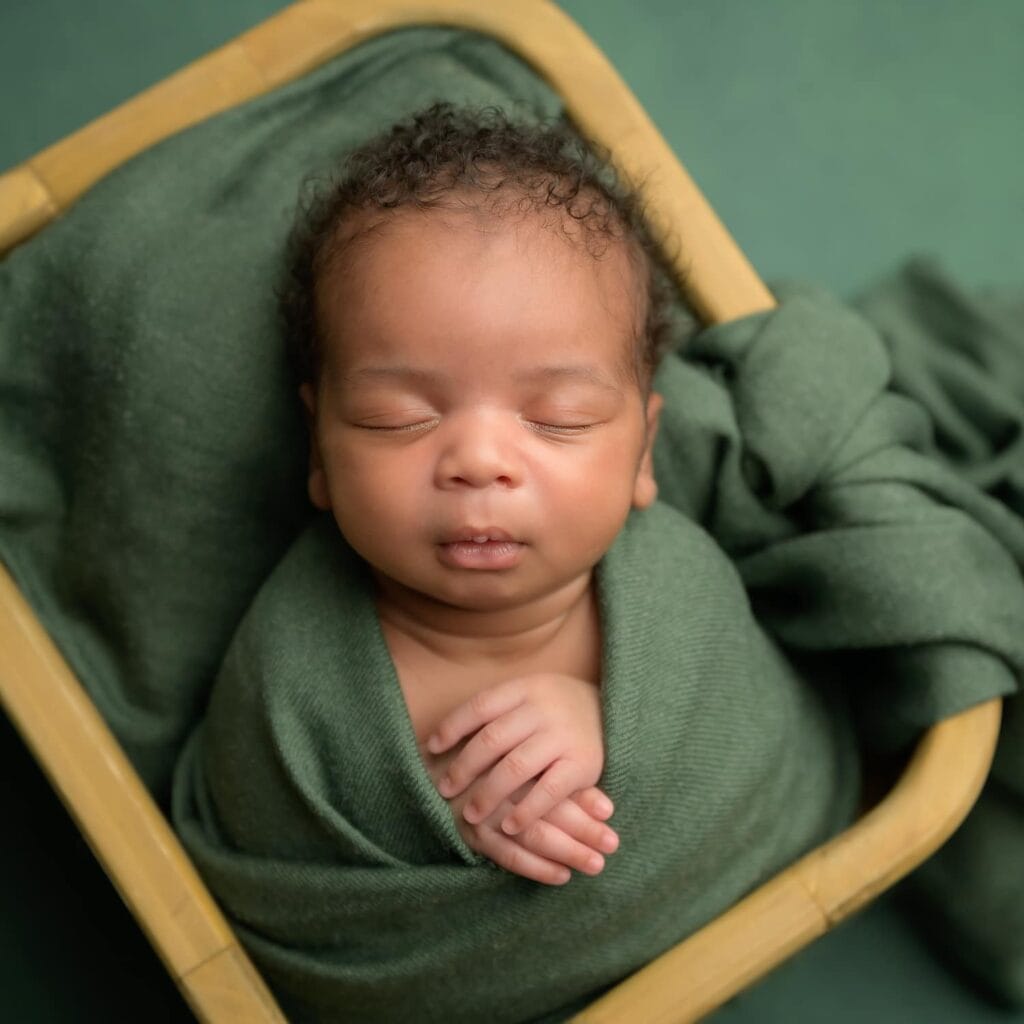 Newborn baby wrapped in a basket at their in-home newborn session in Philadelphia